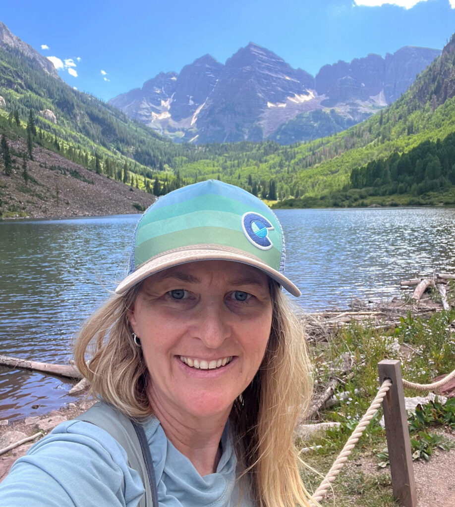 Anna Lookabill standing in front of the maroon bells mountains and lake.
